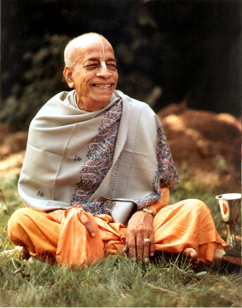 Srila Prabhupada Sitting in a field smiling